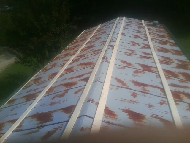 Rusted metal roof panels with new wood purlins before replacement — Storm Damage Roof Repair in Elmaton by Roofing Brothers