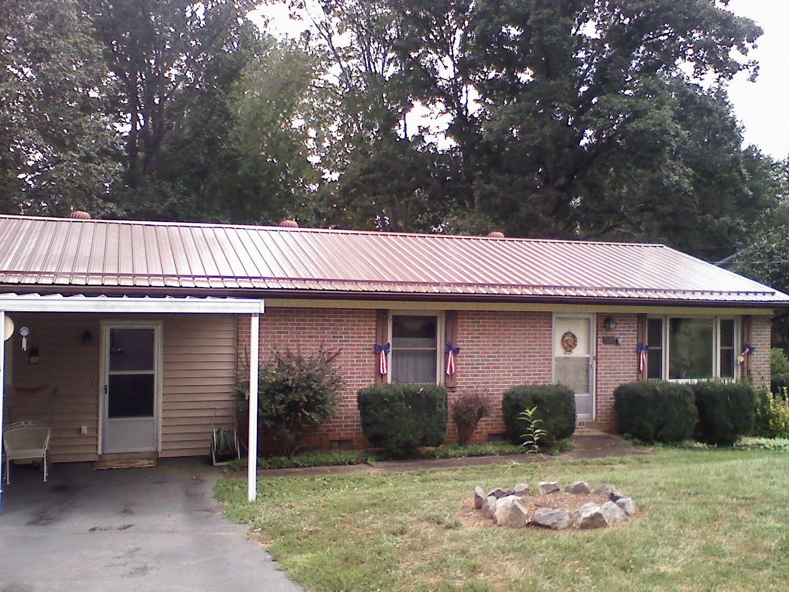Bronze metal roof and carport on a brick ranch home — Roof Repair work by our crew in Elmaton